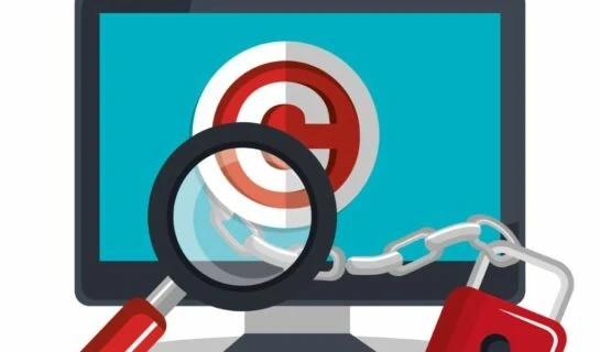 Copyright protection: magnifying glass, chain, and lock in front of a computer screen.