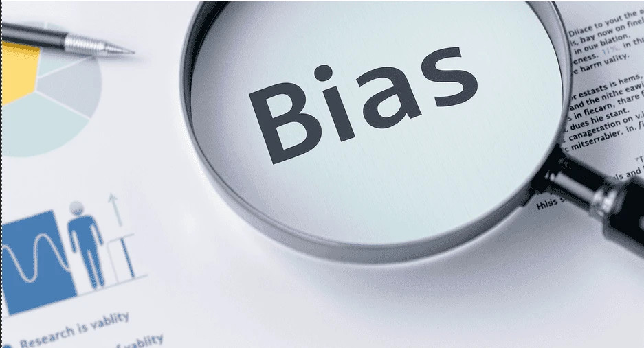 A tidy workspace with research charts, data sheets, and a magnifying glass highlighting the word "Bias" on a paper, symbolizing research bias.
